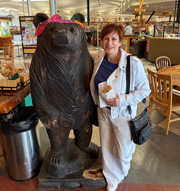 next to wooden bear statue at autographing